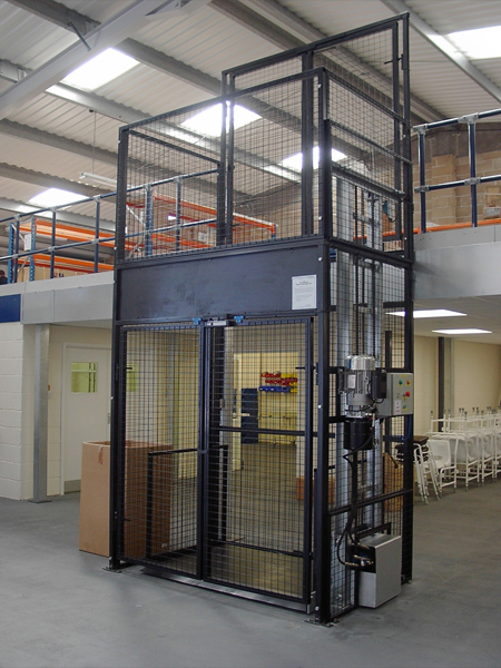 A metal cage in a warehouse with a goods lift