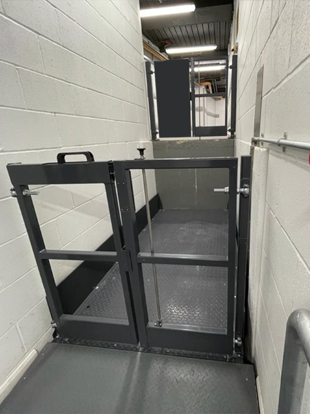 Entrance to building interior via metal door and ramp, intended for goods lift